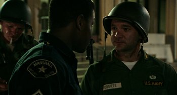 Movie still from “Detroit” (2017), directed by Kathryn Bigelow – A man in a military uniform talking to a police officer; Close Up shot, Over the shoulder angle