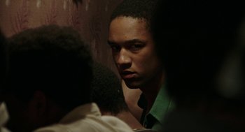 Movie still from “Detroit” (2017), directed by Kathryn Bigelow – A man looking into a mirror while standing next to another man; Close Up shot, Over the shoulder angle