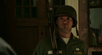 Movie still from “Detroit” (2017), directed by Kathryn Bigelow – A man in a military uniform holding a rifle; Medium shot, Low angle