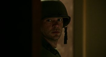 Movie still from “Detroit” (2017), directed by Kathryn Bigelow – A man wearing a military uniform and a helmet; Close Up shot, Low angle