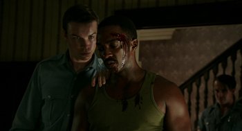 Movie still from “Detroit” (2017), directed by Kathryn Bigelow – A man with blood on his face and another man with blood on his shoulder; Medium shot, Over the shoulder angle