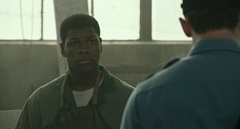Movie still from “Detroit” (2017), directed by Kathryn Bigelow – A man is looking at another man in a room; Close Up shot, Over the shoulder angle