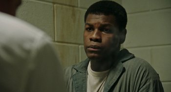 Movie still from “Detroit” (2017), directed by Kathryn Bigelow – A young man looking into a mirror in a jail cell; Close Up shot, Over the shoulder angle