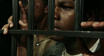 Movie still from “Detroit” (2017), directed by Kathryn Bigelow – Two men behind bars looking out of a jail cell; Close Up shot, High angle