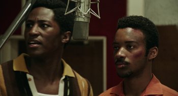 Movie still from “Detroit” (2017), directed by Kathryn Bigelow – Two men standing next to each other in front of a microphone; Close Up shot, Over the shoulder angle