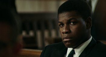 Movie still from “Detroit” (2017), directed by Kathryn Bigelow – A man in a suit and a tie; Close Up shot, Low angle