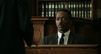 Movie still from “Detroit” (2017), directed by Kathryn Bigelow – A man in a suit sitting in front of a judge; Close Up shot, Over the shoulder angle