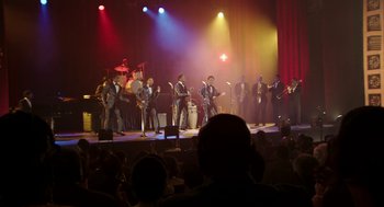 Movie still from “Detroit” (2017), directed by Kathryn Bigelow – A group of men on a stage performing on a stage; Extreme Wide shot, High angle