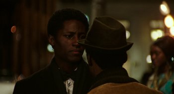Movie still from “Detroit” (2017), directed by Kathryn Bigelow – A man in a suit and a hat standing next to another man in a hat; Close Up shot, Over the shoulder angle
