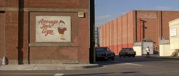 Movie still from “Dodgeball: A True Underdog Story” (2004), directed by Rawson Marshall Thurber – Two cars parked on the side of the street; Wide shot, Low angle