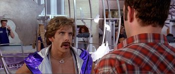 Movie still from “Dodgeball: A True Underdog Story” (2004), directed by Rawson Marshall Thurber – A man with a beard and a mustache is looking at a man in a cage; Close Up shot, Over the shoulder angle
