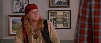Movie still from “Dodgeball: A True Underdog Story” (2004), directed by Rawson Marshall Thurber – A man wearing a pirate's outfit in front of a picture of a baseball team; Close Up shot, Over the shoulder angle