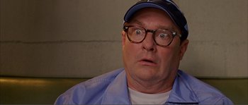 Movie still from “Dodgeball: A True Underdog Story” (2004), directed by Rawson Marshall Thurber – An older man wearing glasses and a blue cap; Close Up shot, Low angle