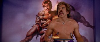 Movie still from “Dodgeball: A True Underdog Story” (2004), directed by Rawson Marshall Thurber – A man holding a donut in front of a painting; Medium shot, Low angle