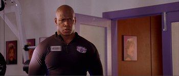 Movie still from “Dodgeball: A True Underdog Story” (2004), directed by Rawson Marshall Thurber – A man standing in front of a door wearing a uniform; Close Up shot, Low angle