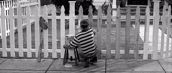 Movie still from “Dodgeball: A True Underdog Story” (2004), directed by Rawson Marshall Thurber – A man painting a fence in black and white; Wide shot, High angle