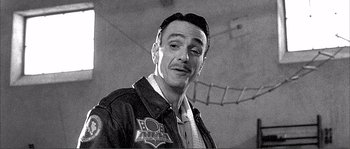 Movie still from “Dodgeball: A True Underdog Story” (2004), directed by Rawson Marshall Thurber – A man in a leather jacket is smiling for the camera; Close Up shot, Low angle