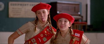 Movie still from “Dodgeball: A True Underdog Story” (2004), directed by Rawson Marshall Thurber – Two young girl scouts pose for a picture; Close Up shot, High angle