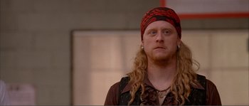 Movie still from “Dodgeball: A True Underdog Story” (2004), directed by Rawson Marshall Thurber – A man with long blonde hair wearing a red bandanna; Close Up shot, Over the shoulder angle