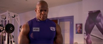 Movie still from “Dodgeball: A True Underdog Story” (2004), directed by Rawson Marshall Thurber – A man in a purple shirt is standing in front of a mirror; Medium shot, Low angle