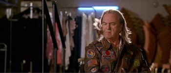 Movie still from “Dodgeball: A True Underdog Story” (2004), directed by Rawson Marshall Thurber – An older man with patches on his jacket is standing in front of clothes; Close Up shot, Low angle
