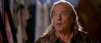 Movie still from “Dodgeball: A True Underdog Story” (2004), directed by Rawson Marshall Thurber – An older man with long hair and a surprised look; Close Up shot, Low angle