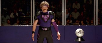 Movie still from “Dodgeball: A True Underdog Story” (2004), directed by Rawson Marshall Thurber – A man dressed in a purple and black costume; Medium shot, Low angle
