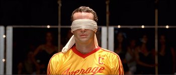Movie still from “Dodgeball: A True Underdog Story” (2004), directed by Rawson Marshall Thurber – A blindfolded soccer player wearing a yellow jersey; Close Up shot, Overhead angle