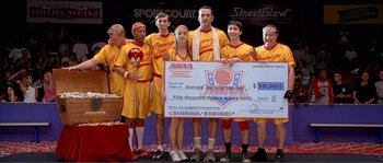 Movie still from “Dodgeball: A True Underdog Story” (2004), directed by Rawson Marshall Thurber – A group of men and women standing next to each other holding a giant check; Medium shot, Overhead angle