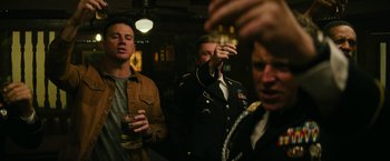 Movie still from “Dog” (2022), directed by Reid Carolin – A group of men standing next to each other holding drinks; Medium shot, Over the shoulder angle