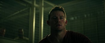 Movie still from “Dog” (2022), directed by Reid Carolin – A person in a dark room; Close Up shot, Low angle