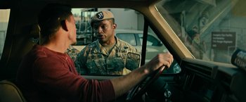 Movie still from “Dog” (2022), directed by Reid Carolin – A man in a military uniform is in the drivers seat of a car; Medium shot, Over the shoulder angle