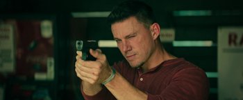 Movie still from “Dog” (2022), directed by Reid Carolin – A person holding a gun; Close Up shot, Low angle