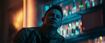 Movie still from “Dog” (2022), directed by Reid Carolin – A person sitting in front of a window; Close Up shot, Low angle