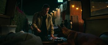 Movie still from “Dog” (2022), directed by Reid Carolin – A man standing at a table with a dog in front of him; Medium shot, Over the shoulder angle