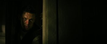 Movie still from “Dog” (2022), directed by Reid Carolin – A man standing next to a wall in a dark room; Medium shot, Low angle