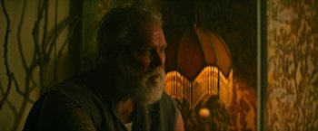 Movie still from “Dog” (2022), directed by Reid Carolin – An old man with a beard is sitting in front of a lamp; Close Up shot, Low angle