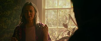 Movie still from “Dog” (2022), directed by Reid Carolin – An older woman is holding a flower in front of a window; Close Up shot, Over the shoulder angle