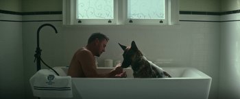 Movie still from “Dog” (2022), directed by Reid Carolin – A man and a dog in a bath tub in a bathroom; Wide shot, High angle