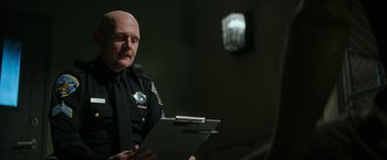 Movie still from “Dog” (2022), directed by Reid Carolin – A police officer is holding a clipboard; Close Up shot, Over the shoulder angle