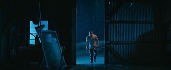 Movie still from “Dog” (2022), directed by Reid Carolin – A man walking in the rain in a building; Wide shot, Low angle