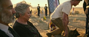Movie still from “Dog” (2022), directed by Reid Carolin – An older woman sitting in front of an american flag; Close Up shot, Over the shoulder angle