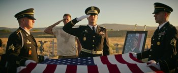 Movie still from “Dog” (2022), directed by Reid Carolin – A man saluting in front of an american flag; Medium shot, Low angle