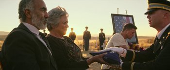 Movie still from “Dog” (2022), directed by Reid Carolin – An older woman is holding an american flag; Medium shot, Over the shoulder angle