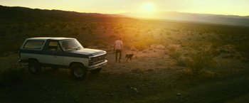 Movie still from “Dog” (2022), directed by Reid Carolin – A man and a dog in a field near a truck; Extreme Wide shot, High angle