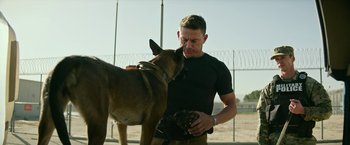 Movie still from “Dog” (2022), directed by Reid Carolin – A man and a dog in a fenced in area; Medium shot, Over the shoulder angle