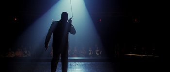 Movie still from “Dreamgirls” (2006), directed by Bill Condon – A man holding a whip in front of an audience; Wide shot, Low angle