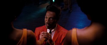 Movie still from “Dreamgirls” (2006), directed by Bill Condon – A man in a red jacket clapping his hands; Close Up shot, Over the shoulder angle