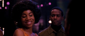 Movie still from “Dreamgirls” (2006), directed by Bill Condon – A man and a woman standing next to each other in front of lights; Close Up shot, Over the shoulder angle