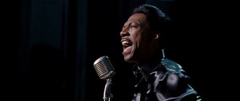 Movie still from “Dreamgirls” (2006), directed by Bill Condon – A man is singing into an old microphone; Close Up shot, Low angle